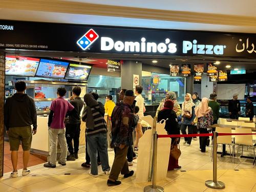 a group of people standing in a dominoes pizza store at Nova Sunrise n Mountain view Hilltop Hotel apartment in Nova Cameron Highlands in Brinchang