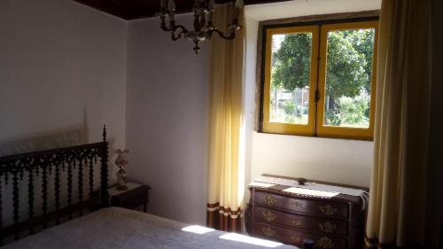 een slaapkamer met een bed, een dressoir en een raam bij Casa da Rosa in Póvoa de Rio de Moinhos