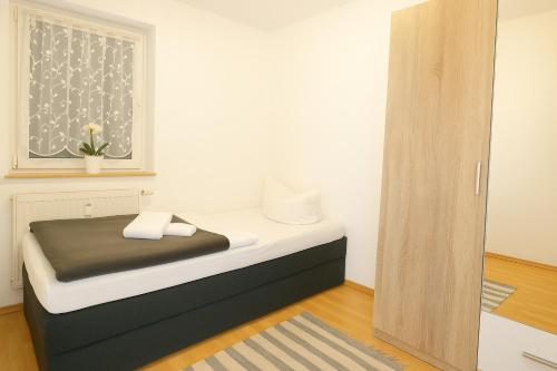 a small bedroom with a bed with a window at SUNNYHOME Monteurwohnungen und Apartments nahe Regensburg in Nittendorf