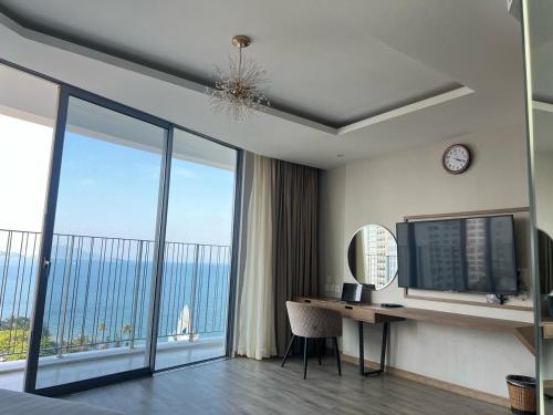 a bedroom with a desk with a computer and a large window at Moonlight Bay Panorama Condotel Ocean View in Nha Trang
