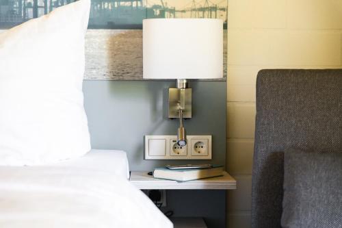 a lamp sitting on a table next to a bed at Zur Rennbahn in Drage