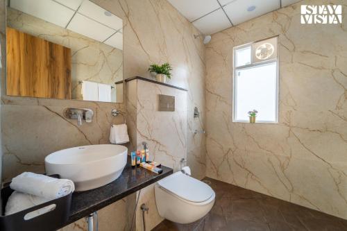 a bathroom with a sink and a toilet at StayVista at The Leo's Manor with Bonfire, Pool in Jaipur