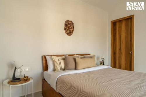 a bedroom with a bed and a clock on the wall at StayVista at The Leo's Manor with Bonfire, Pool in Jaipur