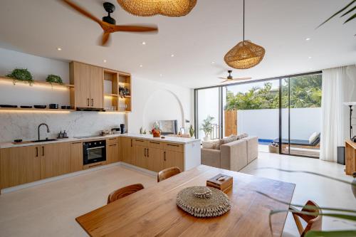 a kitchen and living room with a wooden table at Elements A3 Villa Bingin in Uluwatu