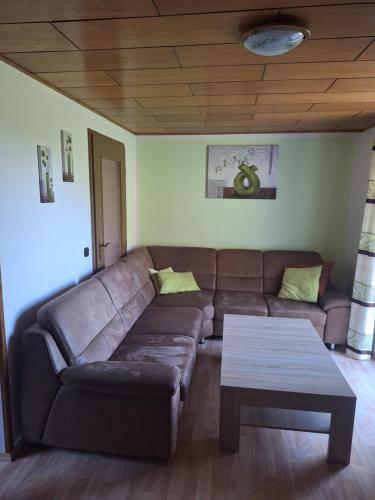 a living room with a brown couch and a coffee table at Ferienwohnung Franz Jägershof 27 in Neukirchen beim Heiligen Blut
