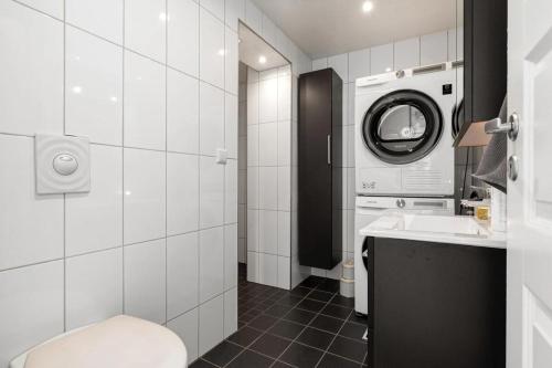 a bathroom with a sink and a washing machine at Modern 2 bedroom apartment in the heart of Tromsø in Tromsø