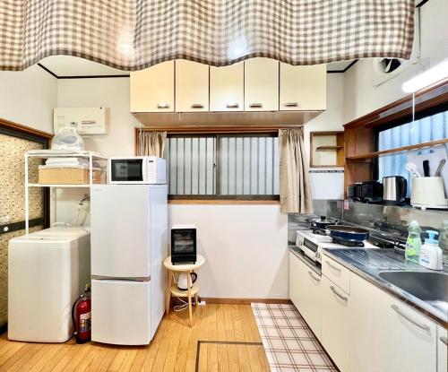 a kitchen with white cabinets and a refrigerator at Direct to Akihabara Shinjuku Max 6 people in Tokyo