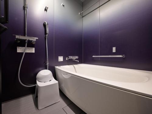 a bathroom with a bath tub and a toilet at Premium Apart MONday GINZA EAST in Tokyo