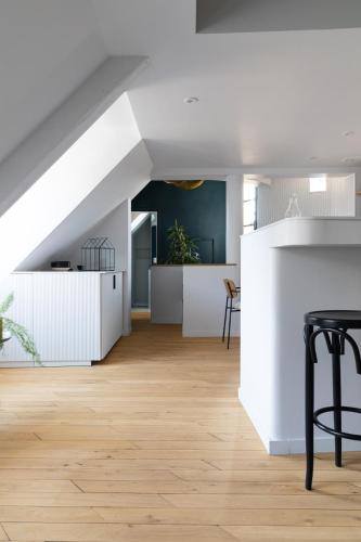 Il comprend une cuisine et un salon avec des murs blancs et du parquet. dans l'établissement Mini loft in Notre Dame district, Île Saint-Louis, Paris, à Paris