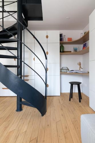 un salon avec un escalier et une table dans l'établissement Mini loft in Notre Dame district, Île Saint-Louis, Paris, à Paris