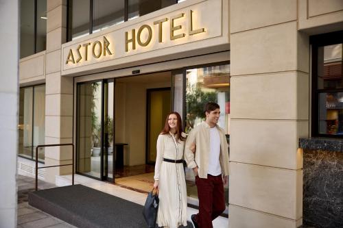 a man and a woman standing in front of a hotel at Astor Hotel Athens in Athens