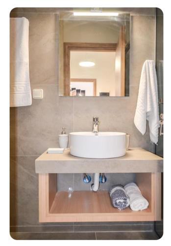 a bathroom with a sink and a mirror at Kamilos apartments in Monastirákion