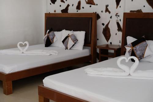 two beds with swans made out of towels at Sundown Resort & Austrian Pension House in Boracay