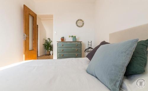 a bedroom with a white bed and a blue dresser at Charmante maison du vieux Coutainville, à 15mn à pied de la mer, classée 3 étoiles in Agon Coutainville
