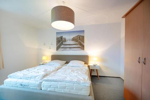 a bedroom with a bed and a painting on the wall at Salzwiesenglück im Haus zwischen den Wassern in Behrensdorf