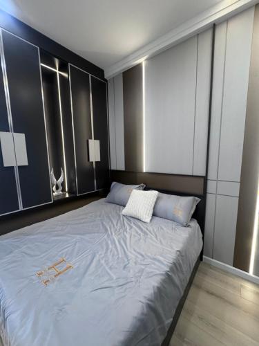 a bedroom with a large bed with blue sheets at Chani Home in Da Nang