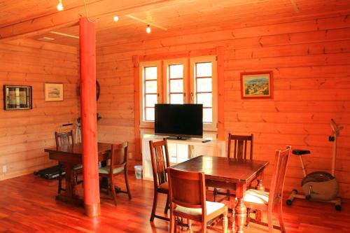 a dining room with a table and a television at 彩の宿虹 in Yamanakako