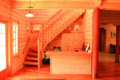 a staircase in a cabin with wooden walls and wooden floors at 彩の宿虹 in Yamanakako