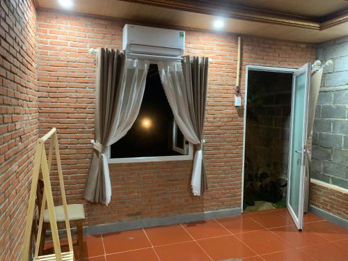 a brick wall with a window with a heater at Suối Xanh Garden in Gia Nghĩa