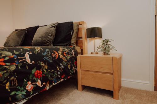 a bedroom with a bed and a table with a lamp at Rigg House - Ideal for Contractors 2 bed 2 bathrooms sleeps 6 free parking in Doncaster