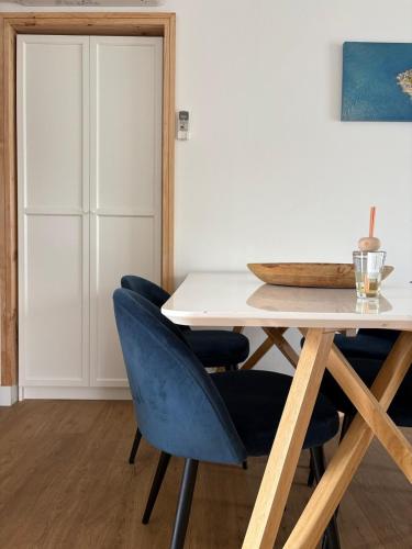 une salle à manger avec une table et des chaises bleues dans l'établissement Agréable Maison ensoleillée avec piscine, au Muy