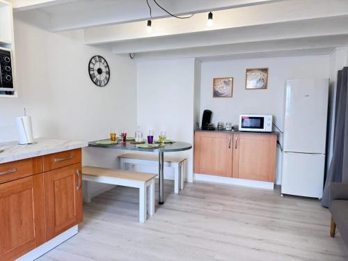 une cuisine avec une table et un réfrigérateur blanc dans l'établissement Appartement de la Lanterne - Résidence des Marées, à Aytré