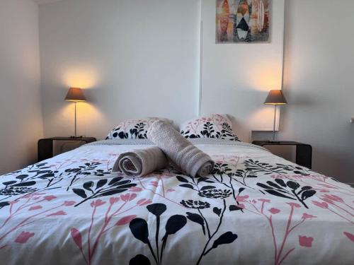 une chambre avec un lit avec une couette fleurie dans l'établissement Appartement de la Lanterne - Résidence des Marées, à Aytré