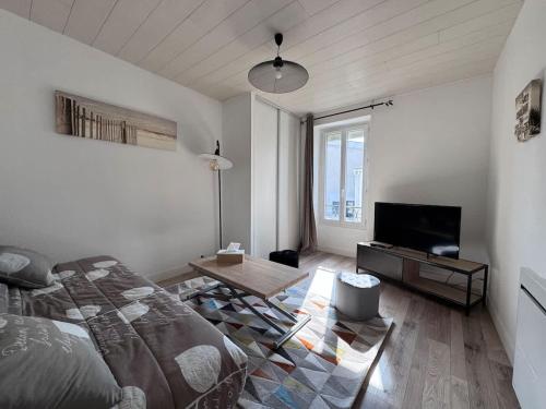 un salon avec un lit et une télévision dans l'établissement Appartement de la Lanterne - Résidence des Marées, à Aytré
