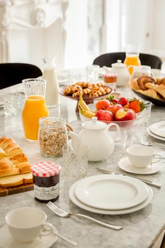 une table recouverte de assiettes de nourriture et de fruits dans l'établissement Merveil - Signature Suite - Champs Elysees -Kleber, à Paris