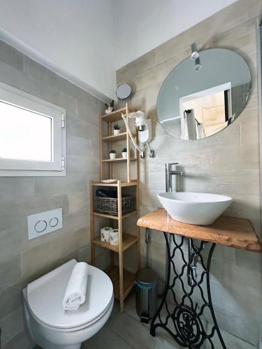a bathroom with a sink and a toilet and a mirror at Nap25guesthouse in Polignano a Mare