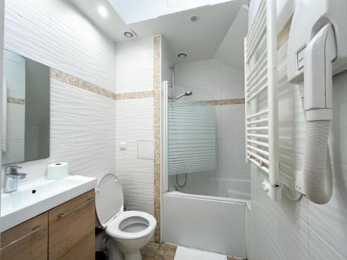 une salle de bain blanche avec des toilettes et un lavabo dans l'établissement Urban Flat 101 - Maire, à Paris