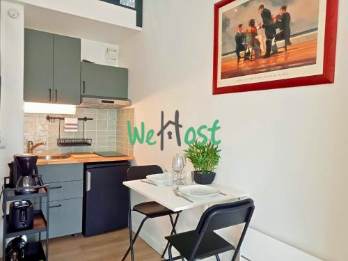 - une cuisine avec une table et des chaises blanches dans la chambre dans l'établissement Bastion Studio central duplex parking, à La Rochelle