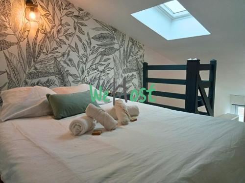 une chambre avec un lit blanc avec des serviettes dessus dans l'établissement Bastion Studio central duplex parking, à La Rochelle