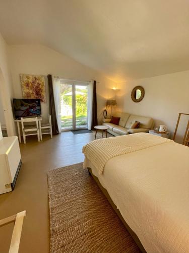 a bedroom with a bed and a living room at Villa provençale Golfe St Tropez climatisée piscine chauffée, Spa, billard, Wifi haut débit pro in Gassin