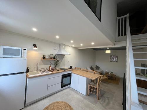 une cuisine avec un réfrigérateur blanc et une table dans l'établissement Maison, à Pierrevert