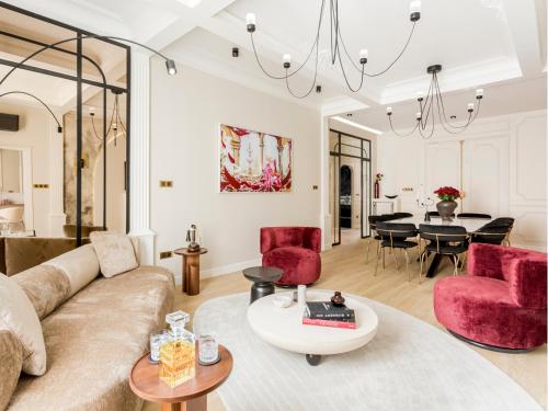 un salon avec un canapé et des chaises rouges dans l'établissement Merveil - Signature Suite - Champs Elysees -Kleber, à Paris