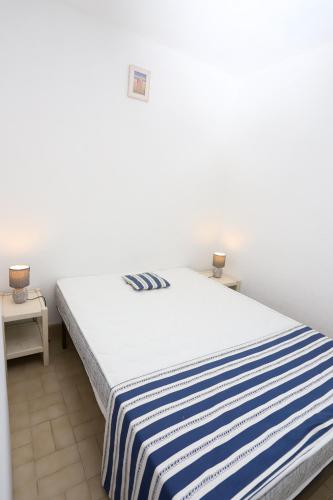 - une chambre avec un lit doté d'une couverture rayée dans l'établissement St Cyprien grande terrasse bel appart lumineux, à Saint-Cyprien