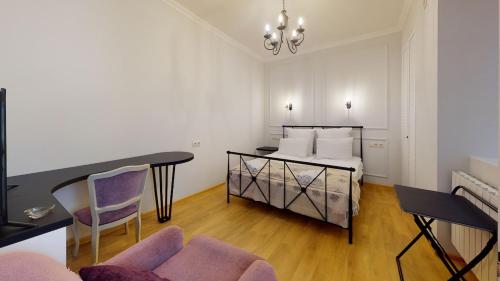 a bedroom with a bed and a table and chairs at Cosy Apartment in the heart of old Tbilisi in Tbilisi City