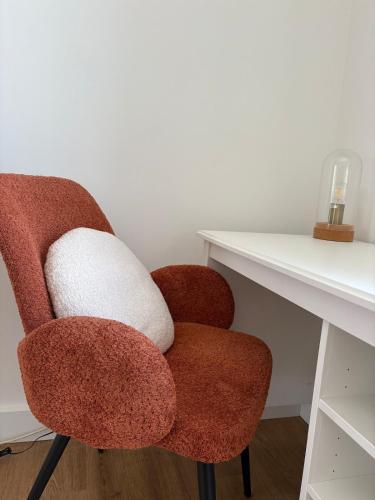 une chaise rouge et blanche assise à côté d'un bureau dans l'établissement Agréable Maison ensoleillée avec piscine, au Muy