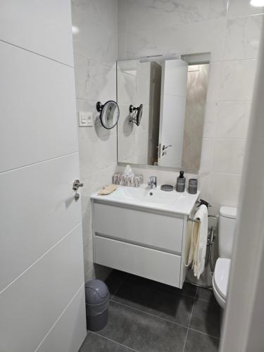 a white bathroom with a sink and a mirror at Mirador del PICO FRENTES in Las Casas