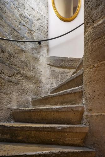 a set of stairs in a stone wall with a mirror at Best Western Aramis Saint Germain in Paris