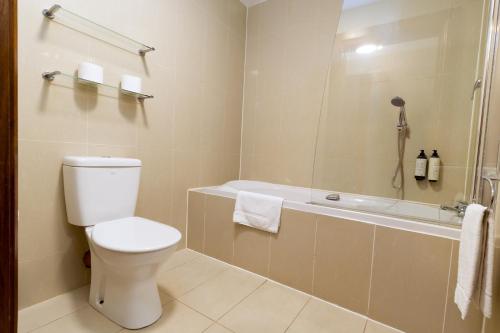 a bathroom with a toilet and a bath tub at Tur an Tsaile - Galway Lakeside Apartments in Galway