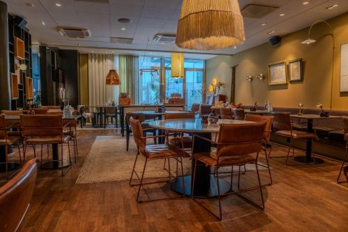 a restaurant with tables and chairs and a bar at Scandic Stora Hotellet in Nyköping