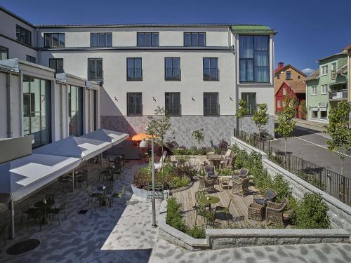 an outdoor patio with tables and chairs and a building at Scandic Stora Hotellet in Nyköping