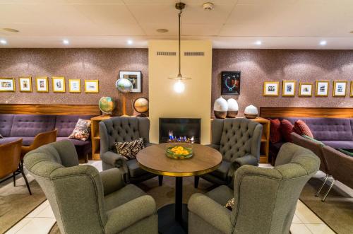 a waiting room with chairs and a table and a fireplace at Scandic Stora Hotellet in Nyköping