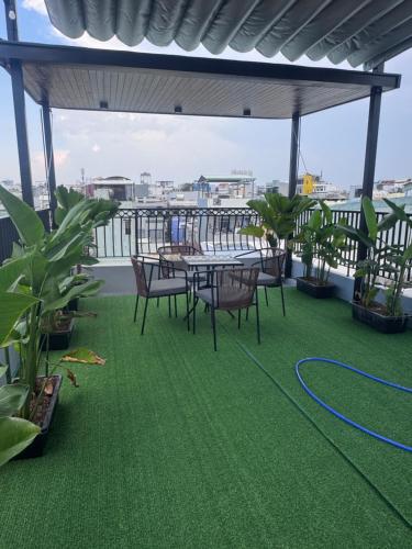 a patio with a table and chairs on a roof at Chani Home in Da Nang