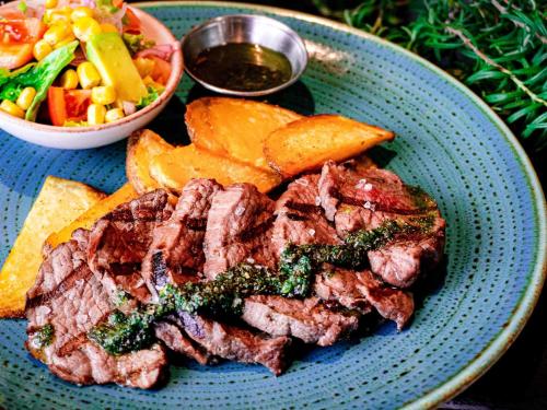 a blue plate with steak and chips and a salad at ibis Barranquilla in Barranquilla