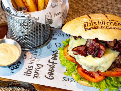 a sandwich with bacon and tomatoes on a bun with fries at ibis Barranquilla in Barranquilla