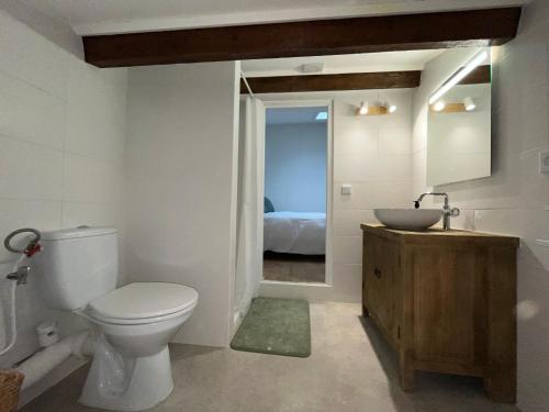 une salle de bain avec toilettes et lavabo et un lit dans l'établissement Maison, à Pierrevert