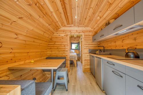 - une cuisine dans une cabane en rondins dotée d'un plafond en bois dans l'établissement Ôtonneauxstress - Plagiste, à Saint-Vivien-de-Médoc